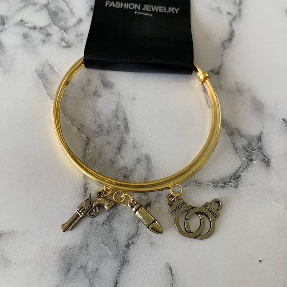 Gold Charm Bangle Bracelet with gun, bullet and handcuff charms. - Picture 2 of 3